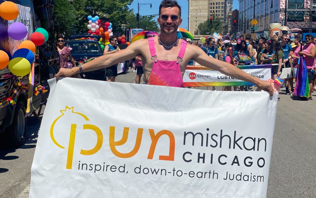 Rabbi Steven Philp holds up a Mishkan Chicago banner at the Chicago Pride Parade.